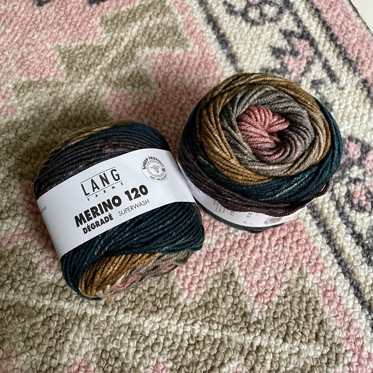 two balls of yarn that go from dark green to browns to pink